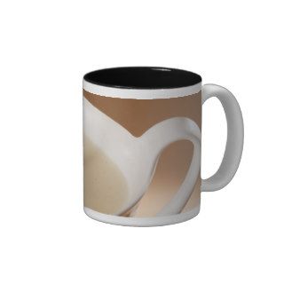 Coffee with milk being poured in mug