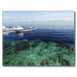 Diving boat arriving above sea and corals post cards