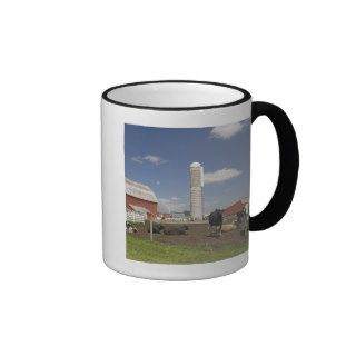 Cows in front of a red barn and silo on a farm mugs