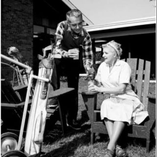 Mid adult man and mother having break from playing golf Poster Print (18 x 24)